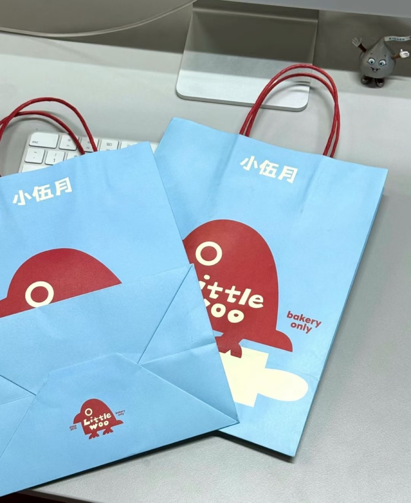 Blue custom printed paper shopping bags with red handles