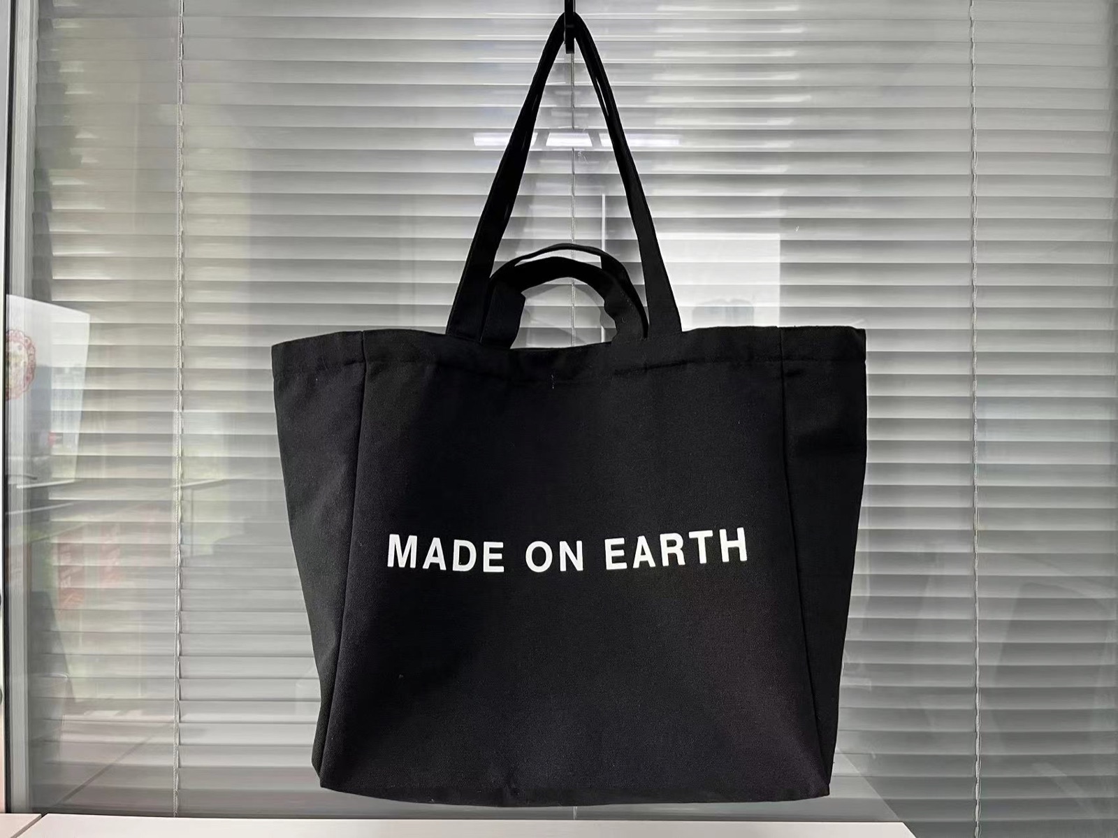 Black canvas tote bag with white custom logo printing
