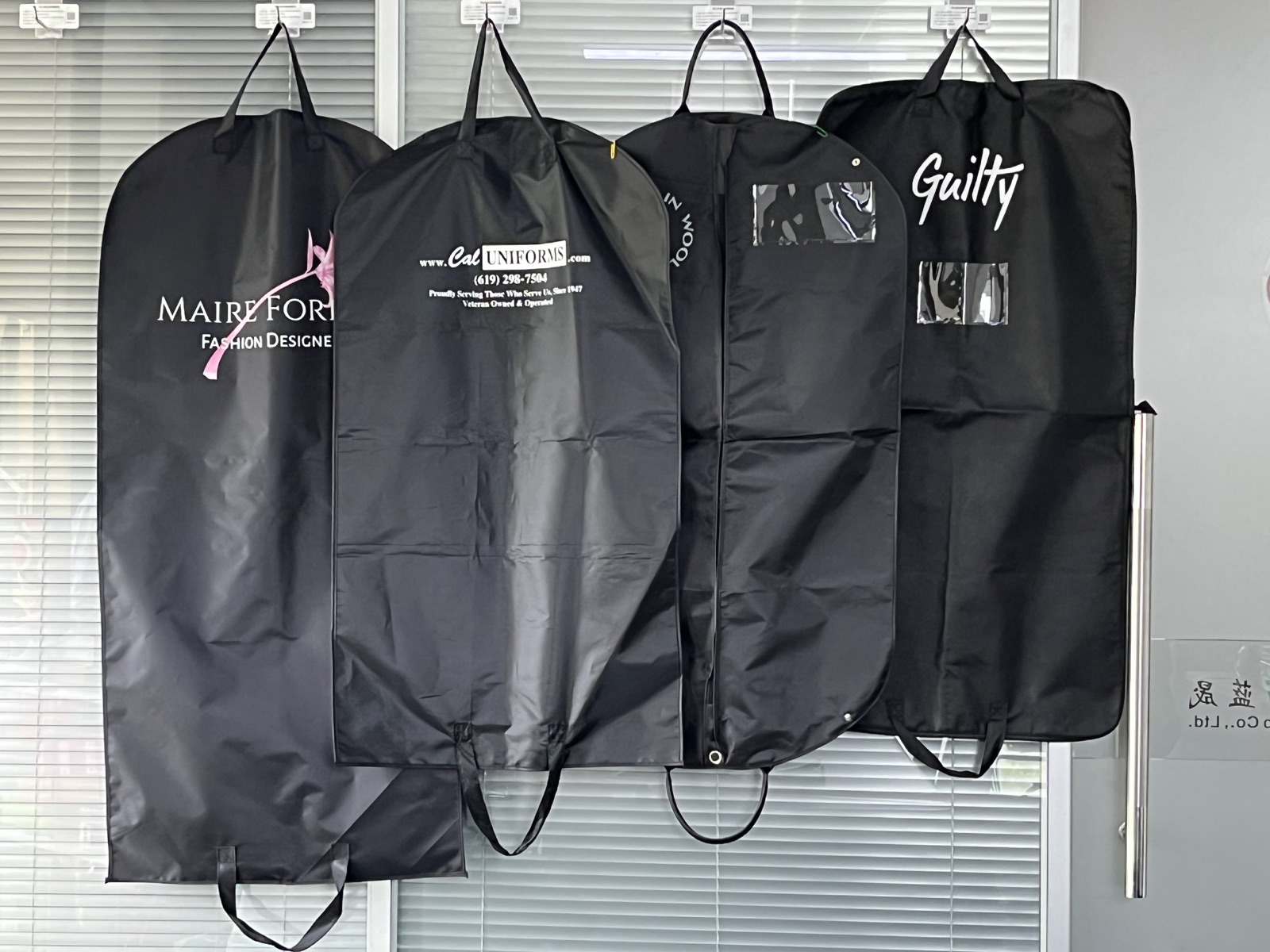 Black custom garment bag with white printed fashion logo